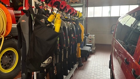 Für die Wasserrettung hängen mehrere Neoprenanzüge neben einem Einsatzfahrzeug der Feuerwehr Heilbronn. So kann die Feuerwehr bei einem Fall des Ertrinkens gleich selbst ins Wasser