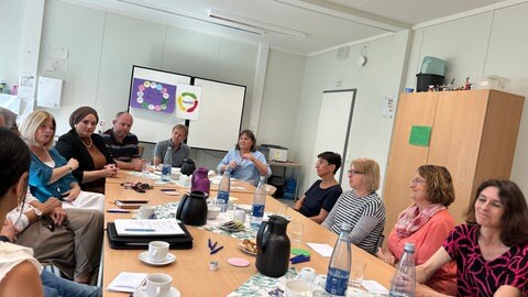 Die Schulleitungen der vier Modellgrundschulen in Ludwigshafen ziehen eine erste Bilanz. Hier ist zu sehen, wie sie an einem Tisch sitzen.