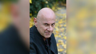 Schriftsteller Andreas Pflüger schaut in die Kamera. | Schriftsteller Andreas Pflüger: Er ist der Meister des tief-recherchierten Thrillers