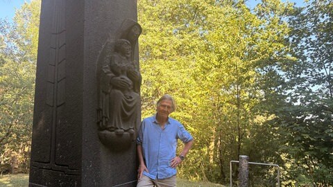 Norbert Scheuer am Gedenkkreuz auf dem Kalvarienberg in Prüm, das an die Katastrophe von 1949 erinnert.