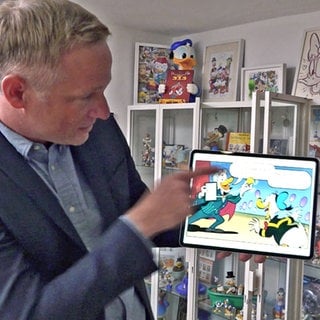 iPad-MagierSimon Pierro hat es in ein Mickey-Mouse-Comic geschafft. Er hält ein iPad in der Hand, auf dem er als Ente in einem Comic mit Donald Duck zu sehen ist.