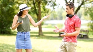 Ein Paar streitet sich in einem Park in München | Warum Paare im Urlaub häufiger streiten