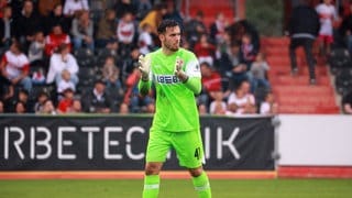 Dennis Seimen, Torwart des VfB Stuttgart, klatscht in die Handschuhe.