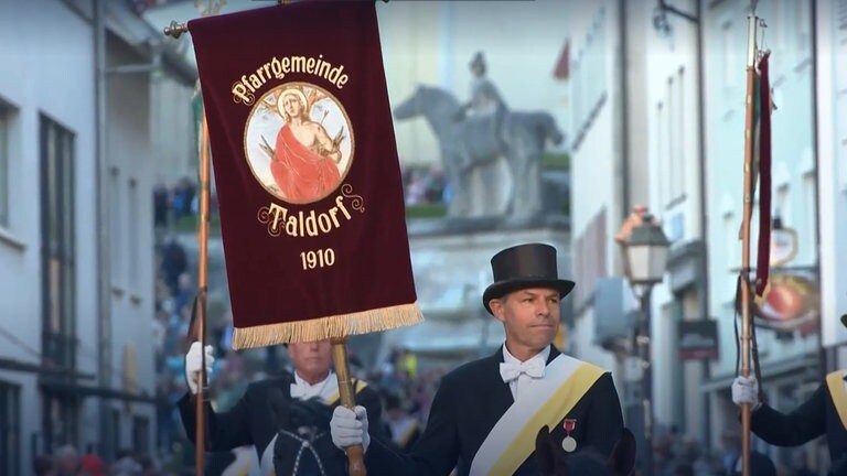 Einer der 1.800 Reiterinnen und Reiter des Blutritts in Weingarten hält eine Standarte.