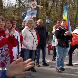 Menschen beim Ulmer Ostermarsch mit Flaggen und Schildern