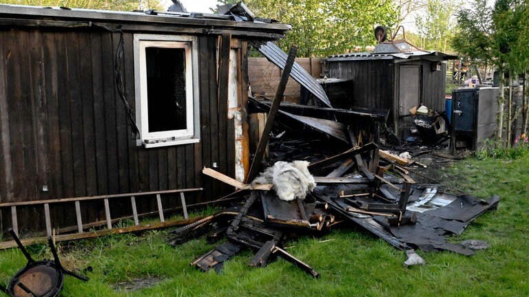 Eine zerstörte Holzhütte. Von der Gartenhütte in der Kleingartenanlage in Langenau ist nach dem Brand nicht mehr viel übrig. 