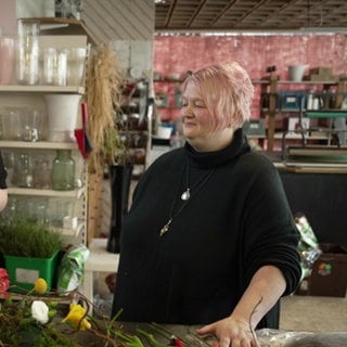 Zwei Frauen stehen an einem Floristentisch