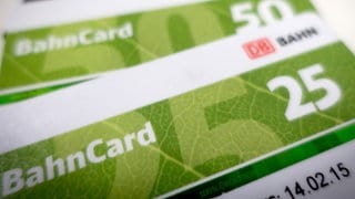 Auf einem Tisch liegen übereinander eine Bahncard 25, eine Bahncard 50 und eine Bahncard 100.