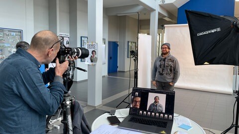 Ein Mann mit Mütze wird fotografiert, er ist Teil der Aktion der TH Bingen – ein Foto für die Demokratie