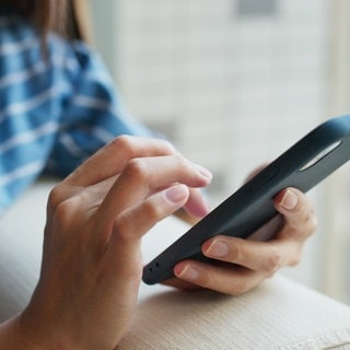Frau tippt auf dem Handy