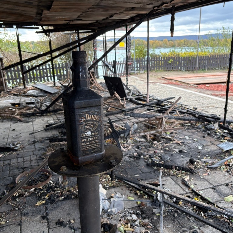 Eine verrußte Flasche steht in der Brandruine vom "Seegugger" auf einem Tisch.
