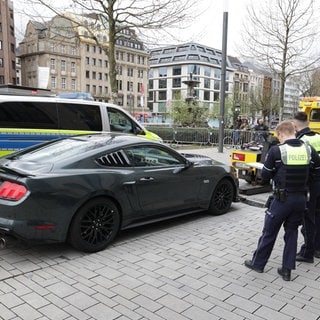 Polizeibeamte stehen während der Fahrzeug-Kontrolle neben einem kontrollierten PKW.  Dieter Schäfer ist zu Gast in SWR1 Leute - er war Chef der Mannheimer Verkehrspolizei - erfolgreich ging er gegen Poser-Szene vor und engagiert sich für mehr LKW-Sicherheit.