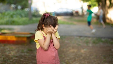 Kleines Kind Mädchen weint bedeckt seine Augen mit seinen Händen fühlt sich verlassen missbraucht, traurig allein 