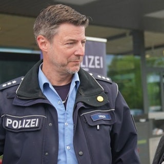 Polizist steht neben einer Seniorin