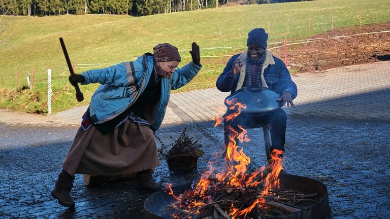 Lioba tanzt, Tayo spielt Handpan am Lagerfeuer hinter dem Fallerhof