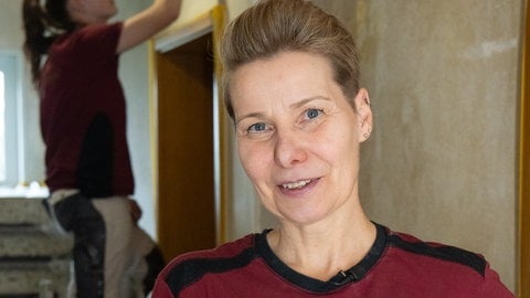 Eine Frau mit kurzen Haaren lacht in die Kamera. Malermeisterin Moni hat es sich zur Aufgabe gemacht, Frauen ins Handwerk zu bringen.