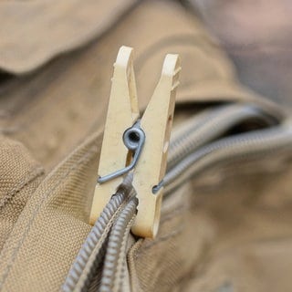 Kaputter Reißverschluss wird mit Wäscheklammer zusammengehalten