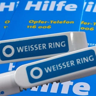 Auf zwei Kugelschreibern ist das blaue Logo des Weißen Ring zu sehen.