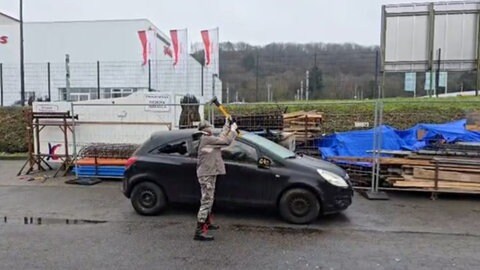Ein Frau aus Trier zertrümmert mit einer Axt ein altes Auto. 