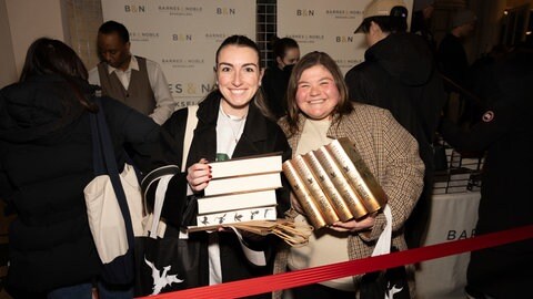 Diese Fans sind „flammengeküsst": Zwei begeisterte „Romantasy"-Leserinnen mit ihrer Beute bei einem Auftritt von Rebecca Yarros in New York im Januar 2025.