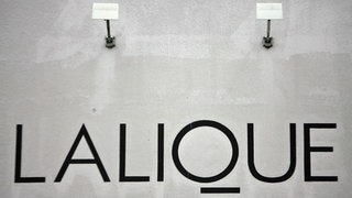 Das Logo des französischen Luxuskristallherstellers Lalique an der Fassade des Werks des Konzerns. 