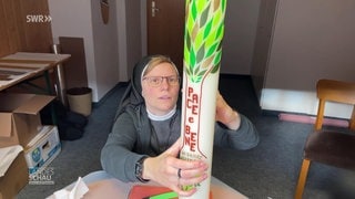 Schwester Tobia dekoriert eine Kerze