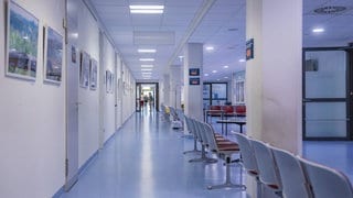 Langer Krankenhausflur mit Stühlen (Symbolbild). Das Westpfalz-Klinikum sichert Spuren nach Gewalt.