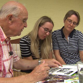 Wolfgang Gehrig ist eines der ältesten Mitglieder der Dossenheimer "Deutschen Jugendkraft". Mit seiner Familie schaut er sich alte Fotos an.