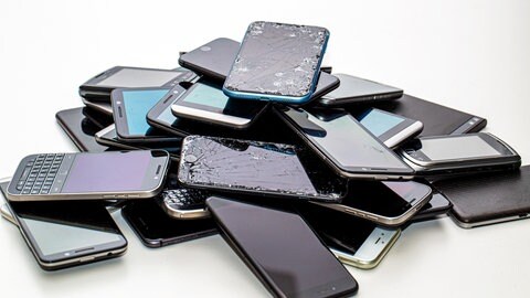 Viele Smartphones auf einem Haufen, teilweise kaputt und zu entsorgen.