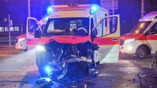 Ein stark beschädigter Rettungswagen steht nach einem Unfall auf der Straße.
