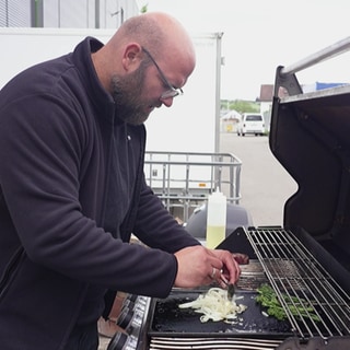 Der Deutsche Grillmeister Ralf Ahrens grillt Zwiebelringe für einen Zwiebelrostbraten.