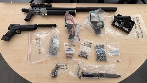 Mehrere Waffen und Stahlkugeln liegen auf einem Tisch. Die Steinschleudern, Luftdruckwaffen und anderen Gegenstände wurden von der Polizei bei einem 66-jährigen Tatverdächtigen aus Senden-Ay gefunden.