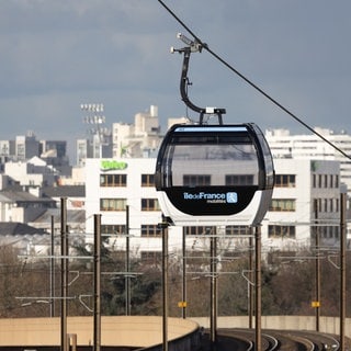 Zwei Gondeln der C1, der ersten städtischen Seilbahn in Paris, die 2025 in Betrieb ging. Jetzt planen Bonn und Herne Deutschlands erste ÖPNV-Seilbahn und kämpfen mit großen bürokratischen Hürden.