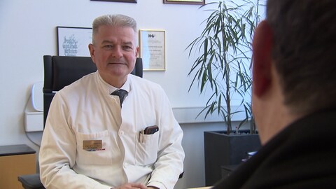 Ein Mann in Arzt-Kittel.