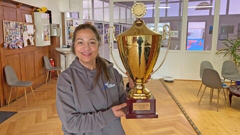 SWR1 Neuanfang: So wurde Mey Alasadi vom Mobbing Opfer zur Karate Meisterin. Mey präsentiert stolz ihren Meister-Pokal der Deutschen Einzelmeisterschaft in Karate 1995