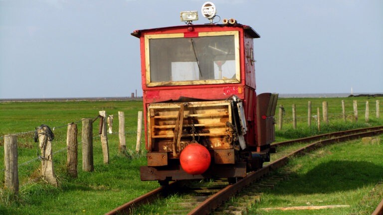 Nicht die rote Lola sondern die rote Lore von Oland. Jede Lore wurde individuell von den Halligbewohnern gebaut. Puffer hat keine einzige; dafür bedient man sich beim Schiffsverkehr mit Fendern vorne und hinten.