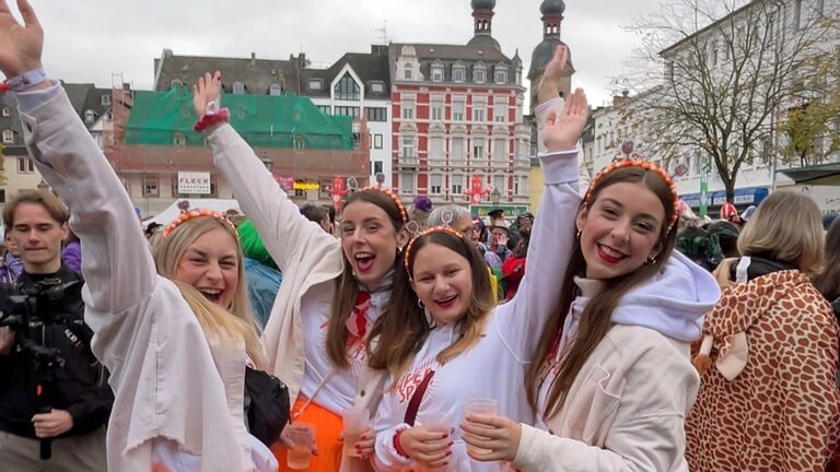 Vier junge Frauen strahlen beim Karnevalsauftakt in Koblenz am 11. November 2024 in die Kamera. 