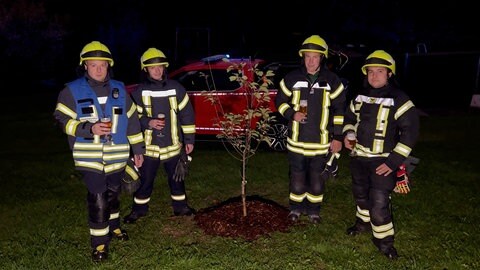 Die Feuerwehrkameraden freuen sich über den neu gepflanzte Kirschbaum auf dem Gelände der Feuerwehr in Winterbach.