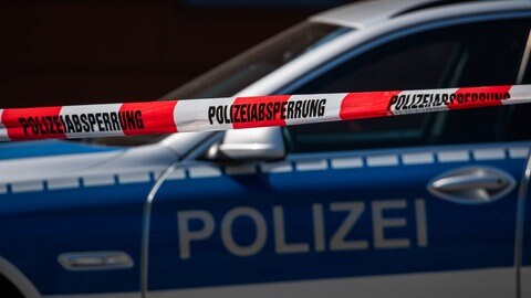 Ein Polizeiauto steht hinter einem Absperrband. In Kusel hat sich nun der Verdacht bestätigt, dass eine Frau getötet wurde.