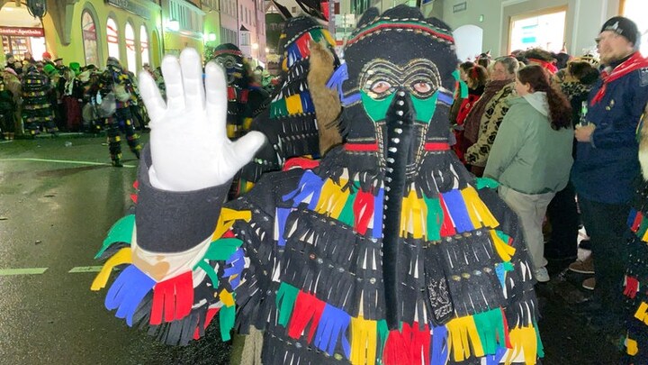 Ein Hänsele aus Überlingen winkt mit der Hand: Charakteristisch für diese Hästräger ist vor allem die schwarze Maske mit dem langen Rüssel.