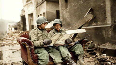 Zwei US-Soldaten sitzen nach dem 2. Weltkrieg in den Trümmern von Koblenz auf einem Sofa auf der Straße