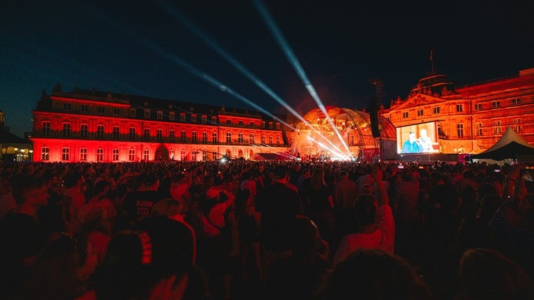 Neues Schloss mit Bühne und Publikum am Abend