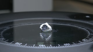 Ein Meteorit auf einer Platte unter einem Mikroskop