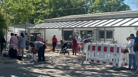 Menschen warten darauf, dass die Lebensmittelausgabe bei der Ludwigshafener Tafel beginnt.