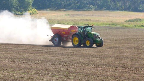 Ein Traktor bringt Kunstdünger aufs Feld, damit Pflanzen genug gelösten Stickstoff im Boden haben. Die Uni Freiburg entwickelt Ansätze, wie Pflanzen mithilfe von Bakterien selbst Stickstoff gewinnen können - statt ihn im energieintensiven Haber-Bosch-Verfahren überwiegend aus Erdgas zu erzeugen.