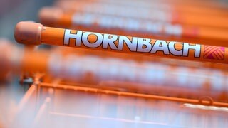 Das Hornbach-Logo auf einem Einkaufswagen. Im Geschäftsjahr 202425 konnte das Unternehmen den Umsatz leicht steigern.