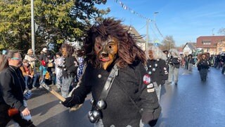 Ein wilder Maskenträger mit zersaustem Haar in Neuravensburg auf dem Narrensprung.