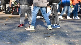 Gruppe von Schülern steht auf dem Pausenhof. Zahl rechtsextremer Straftaten an Schulen steigt.