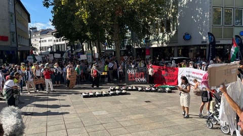 Demonstrierende mit Plakaten am Ulmer Münsterplatz. Mehrere hundert Menschen haben in Ulm gegen den israelischen Rüstungskonzern Elbit und für ein freies Palästina demonstriert.