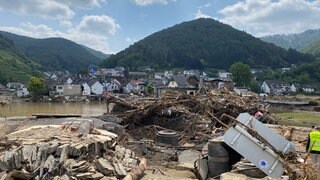 Wenige Tage nach der Flutkatastrophe im Ahrtal staute sich wie hier in Rech der Unrat. Deutlich erkennbar sind auch die Zerstörungen an den Häusern, die in vielen Fällen auch Winzer trafen.